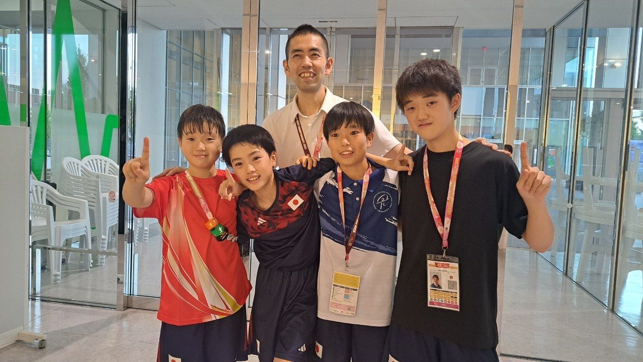 大会会場で選手と代表が並ぶ記念写真
