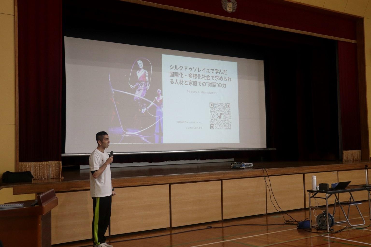 講演会で参加者に向けて話す粕尾将一